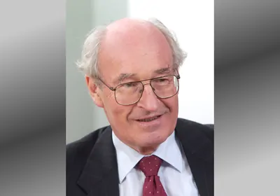 Man in glasses smiling, looking off camera